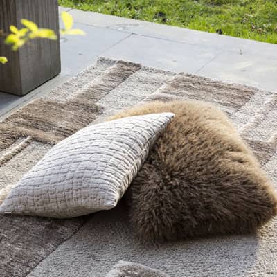 coussin fausse fourrure et coussin coton au sol